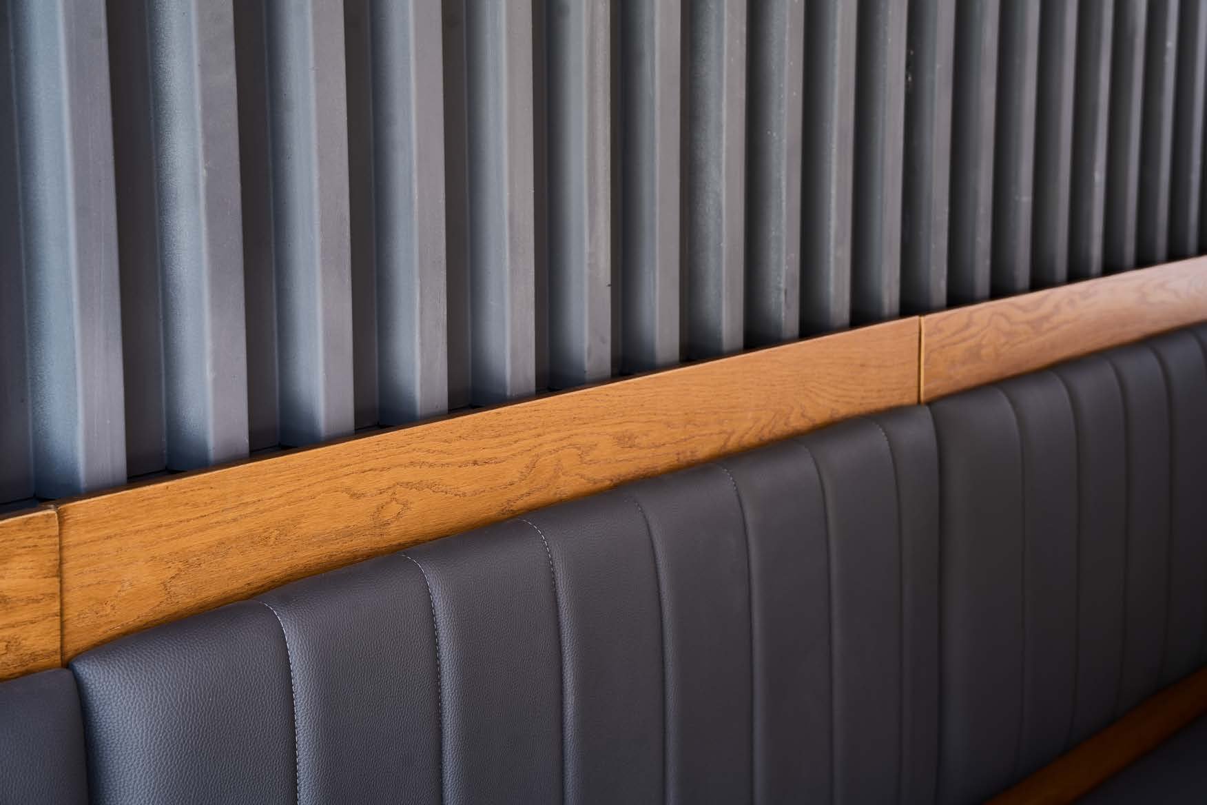 Macro detail of dark leather banquette seating — MCC fit-out and finishing works