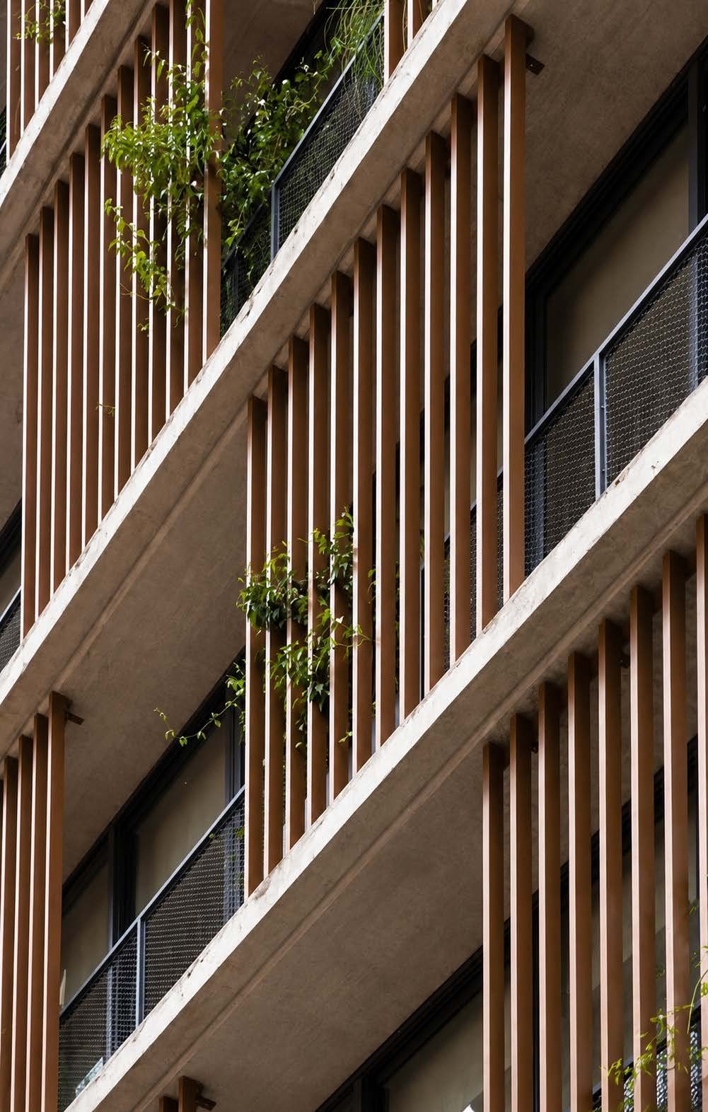 Wood-slat balconies with greenery, architectural detail from an MCC project — the signature cover image of the MCC company profile