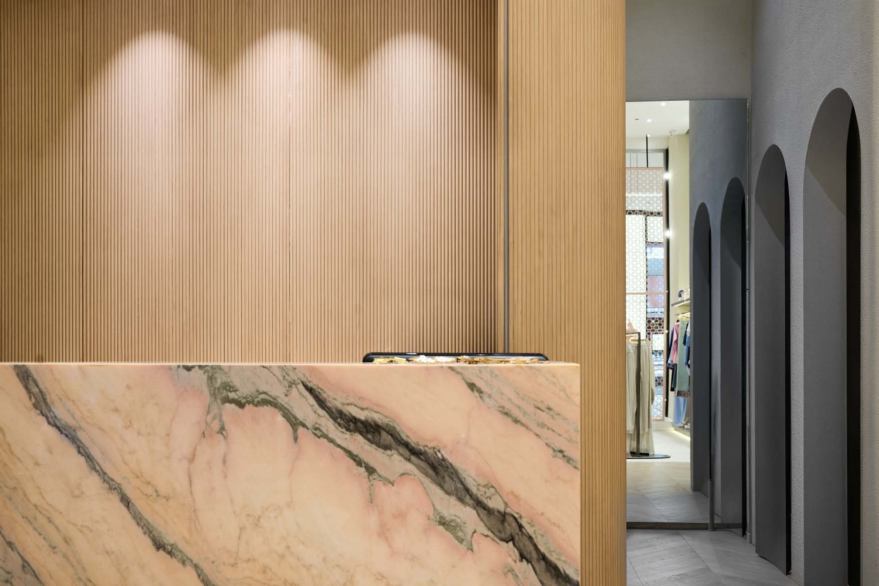 Warm marble counter and arched hall interior — the Finish stage of the MCC delivery model