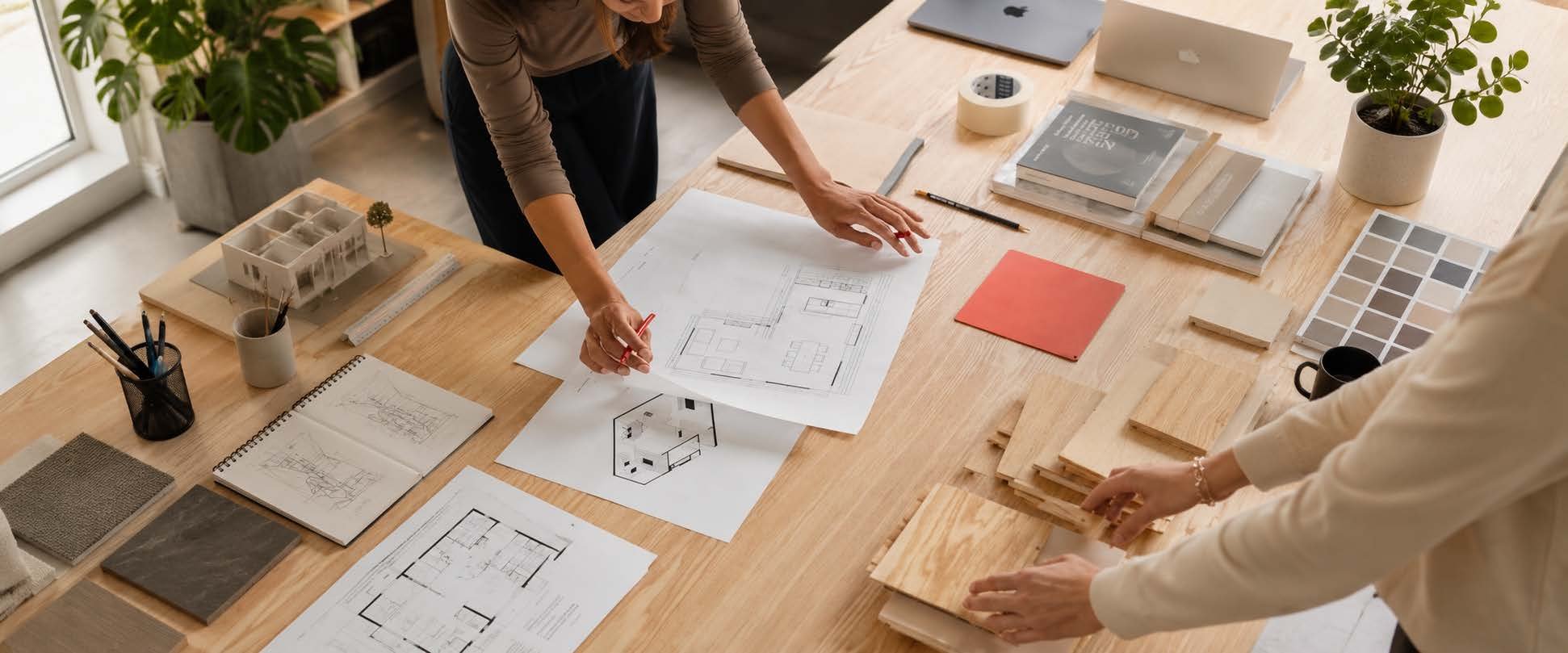 Overhead view of hands reviewing floor plans and material swatches